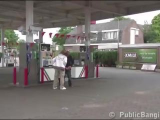 Zeer zwanger jong vrouw publiek trio bij een gas station